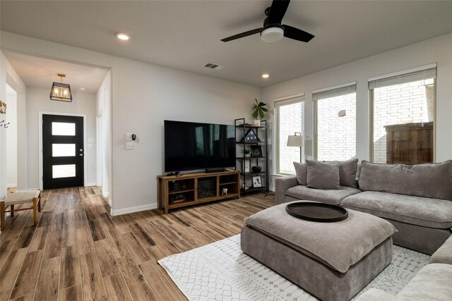 living room featuring wood-type flooring and ceiling fan