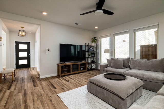 living room featuring recessed lighting, wood finished floors, visible vents, and baseboards