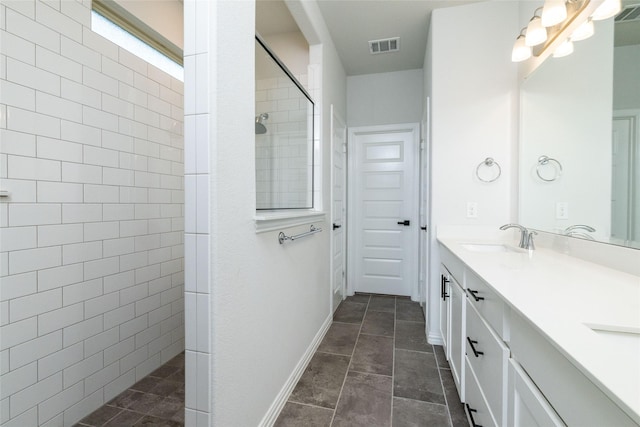 bathroom with vanity and a tile shower