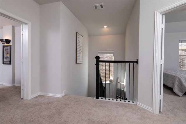 hallway with light colored carpet and plenty of natural light