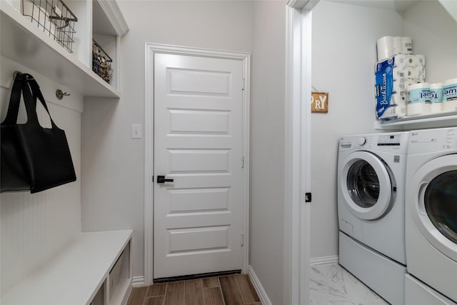 laundry room featuring marble finish floor, laundry area, separate washer and dryer, and baseboards