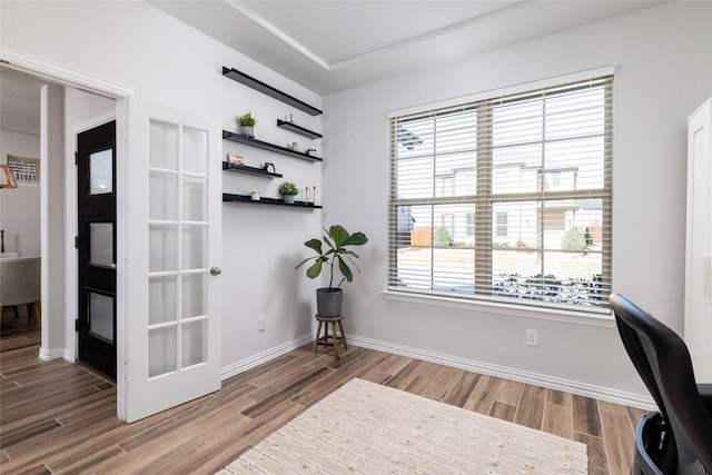 unfurnished office featuring wood tiled floor and baseboards