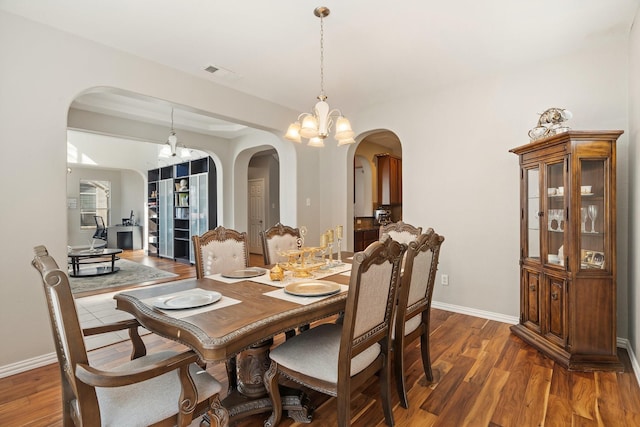 dining space featuring dark hardwood / wood-style flooring and a chandelier