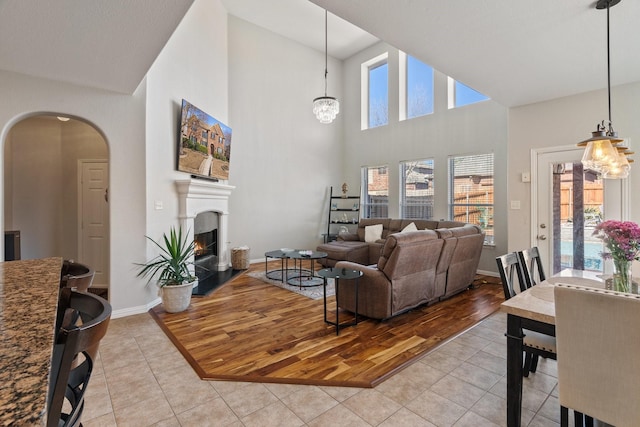 tiled living room featuring a high ceiling and a chandelier