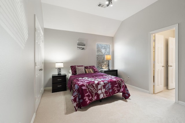 bedroom featuring lofted ceiling and light carpet