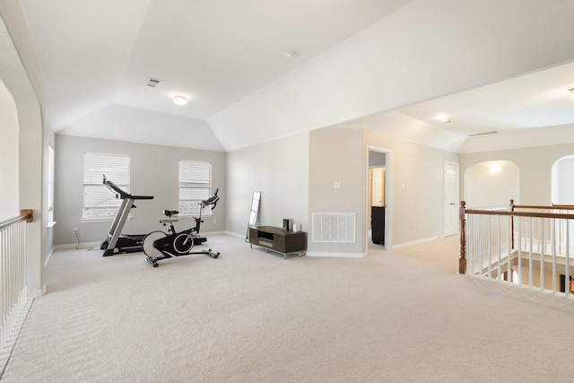 workout area featuring light colored carpet and lofted ceiling