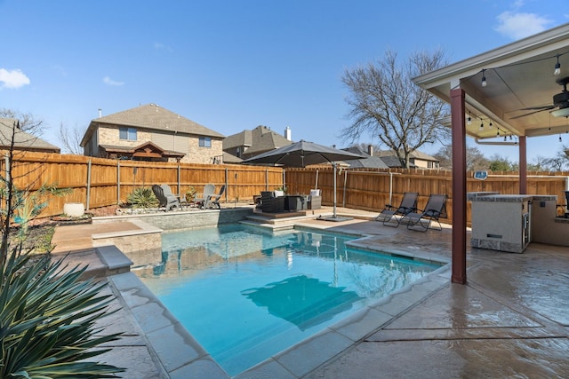 view of swimming pool featuring ceiling fan and a patio area