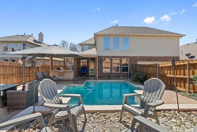 view of pool with a patio, exterior bar, and an outdoor kitchen