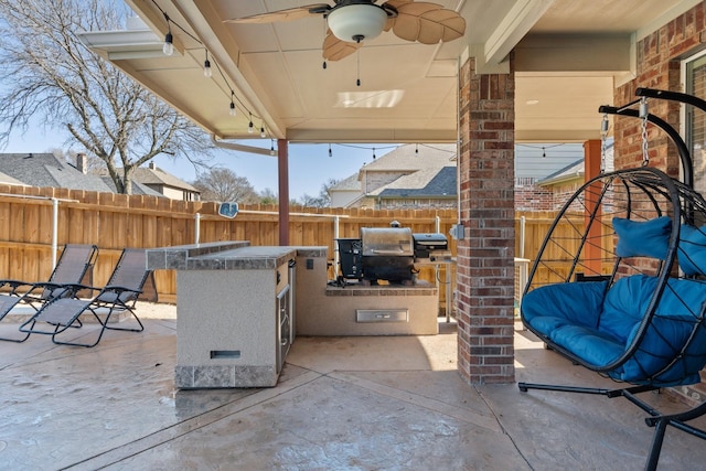 view of patio with ceiling fan, exterior bar, and exterior kitchen