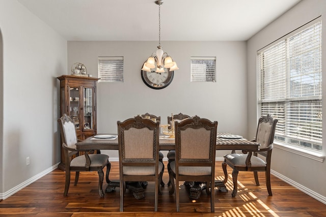 dining room featuring dark wood-type flooring and an inviting chandelier