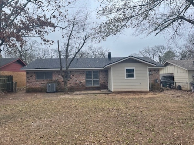 back of property featuring a yard and central AC