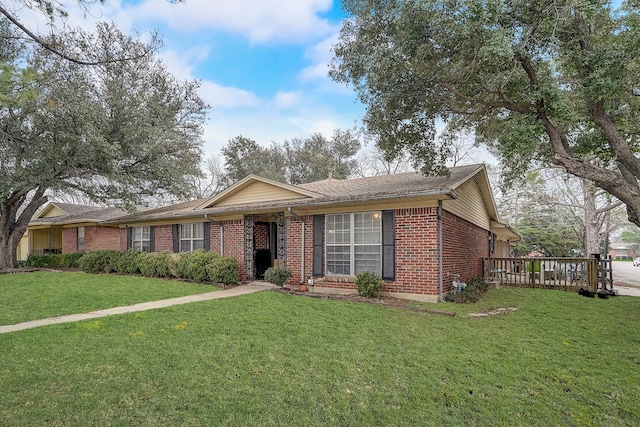 single story home with a front yard and a deck