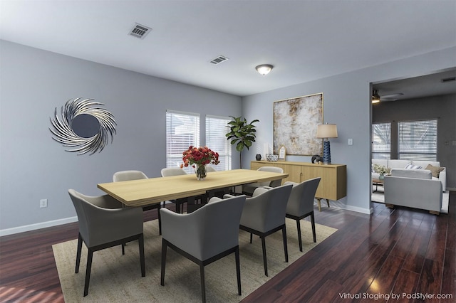 dining space featuring dark wood-type flooring, visible vents, and baseboards