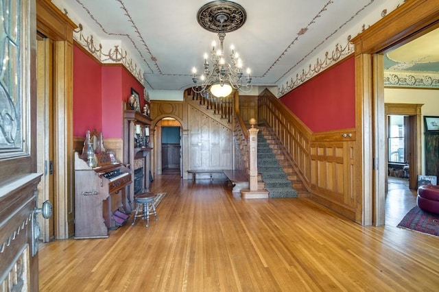 unfurnished living room with an inviting chandelier and light wood-type flooring