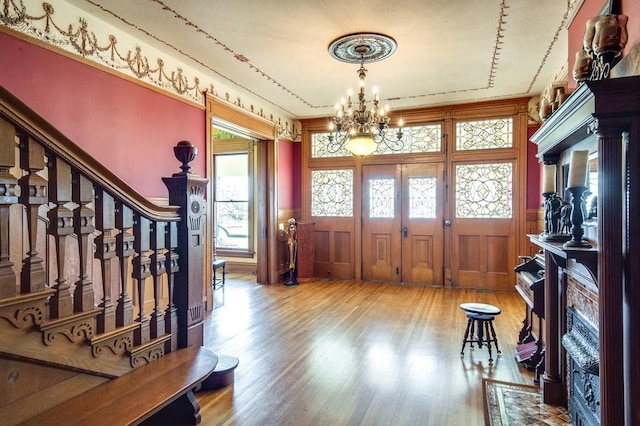 entryway with an inviting chandelier and wood-type flooring