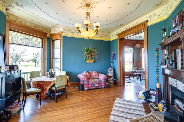 dining room featuring a high end fireplace, hardwood / wood-style floors, and a chandelier