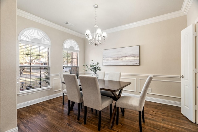 dining room featuring dark hardwood / wood-style flooring, crown molding, and an inviting chandelier