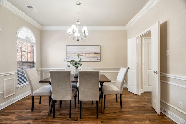 dining area with crown molding, dark hardwood / wood-style floors, and a chandelier