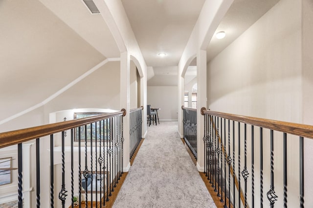 hallway with vaulted ceiling and carpet