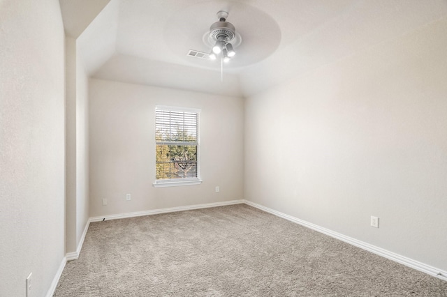 carpeted spare room featuring vaulted ceiling and ceiling fan