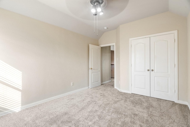 unfurnished bedroom with vaulted ceiling, light carpet, ceiling fan, and a closet