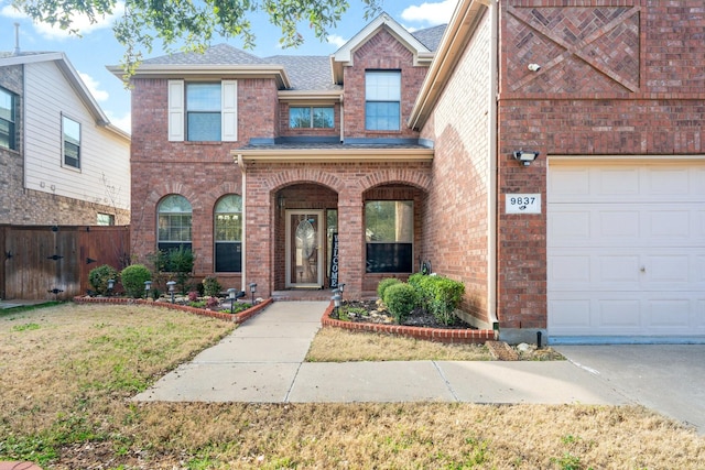 view of front of house with a garage, a front yard, and a porch