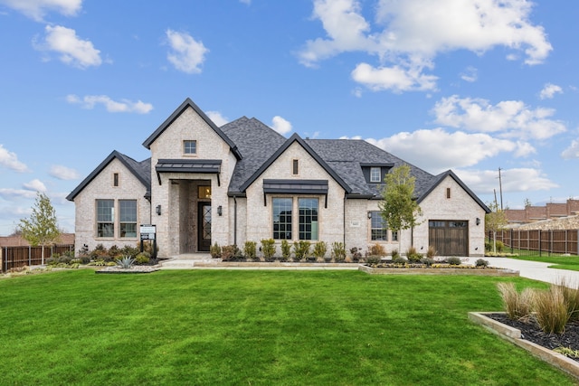 french country style house featuring a garage and a front lawn