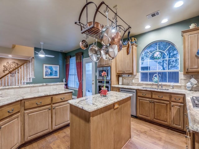 kitchen with a center island, tasteful backsplash, visible vents, appliances with stainless steel finishes, and a sink