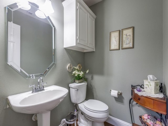 bathroom with visible vents, a sink, toilet, and baseboards