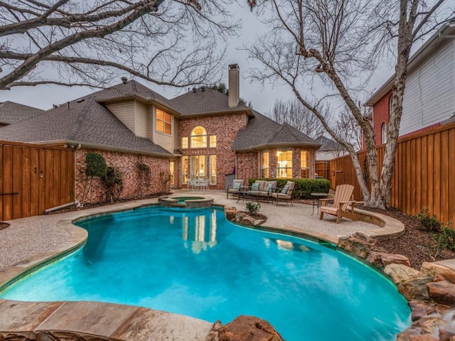 view of swimming pool with a fenced backyard, a pool with connected hot tub, and a patio