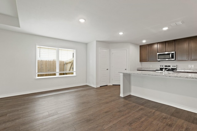 2413 Dahlia Dr, Fort Worth, TX 76123 - kitchen with stainless steel microwave, range, dark wood-style floors, baseboards, and recessed lighting