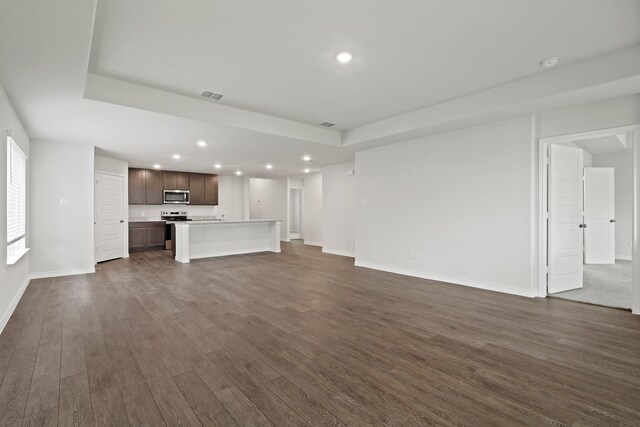 2413 Dahlia Dr, Fort Worth, TX 76123 - unfurnished living room featuring dark wood finished floors, recessed lighting, baseboards, and a raised ceiling