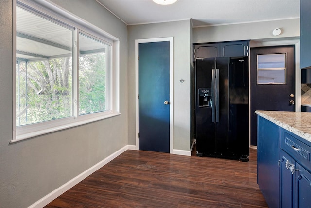 kitchen with black fridge, ornamental molding, blue cabinets, and dark hardwood / wood-style floors