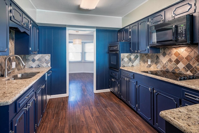 kitchen with light stone countertops, blue cabinetry, sink, and black appliances