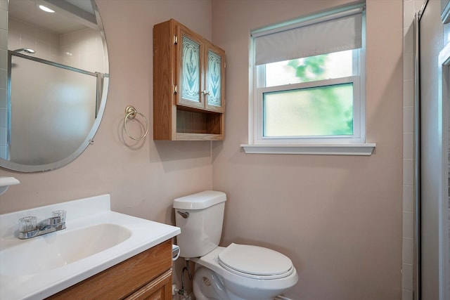 bathroom with vanity, toilet, and a shower with shower door