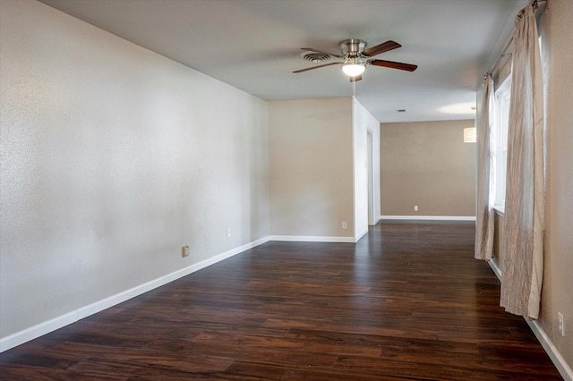 empty room with ceiling fan and dark hardwood / wood-style flooring