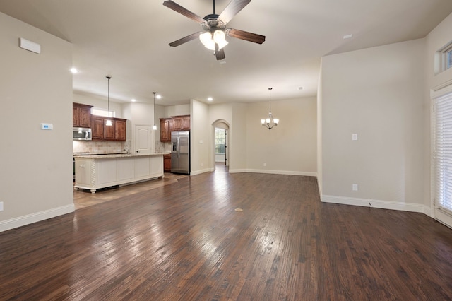 unfurnished living room featuring dark hardwood / wood-style floors and ceiling fan with notable chandelier