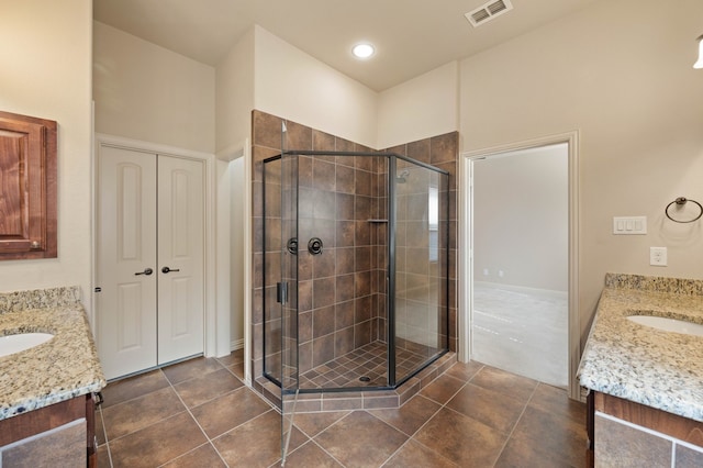 bathroom with vanity, an enclosed shower, and tile patterned flooring