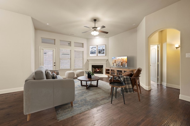 living room featuring ceiling fan and dark hardwood / wood-style flooring