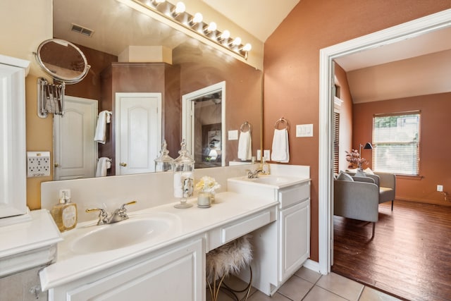 bathroom featuring tile patterned flooring, vaulted ceiling, and vanity