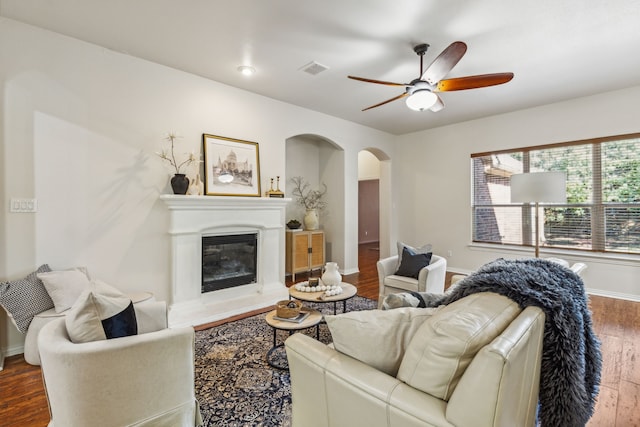 living room featuring dark wood-type flooring and ceiling fan