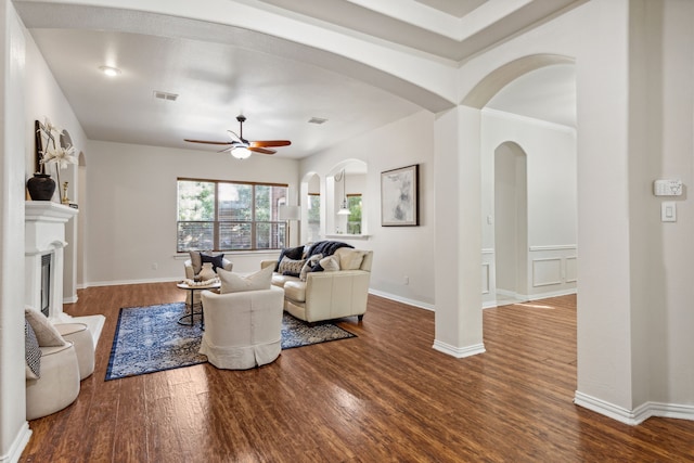 living room with ceiling fan and dark hardwood / wood-style floors