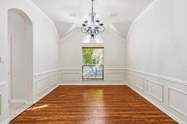 unfurnished room featuring ornamental molding, lofted ceiling, hardwood / wood-style floors, and a notable chandelier