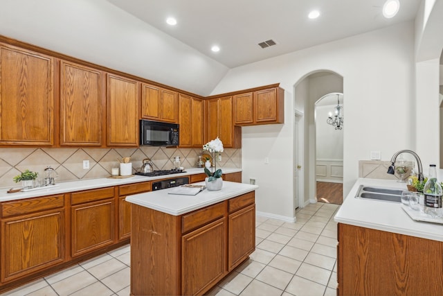 kitchen with light tile patterned flooring, a kitchen island, sink, and decorative backsplash