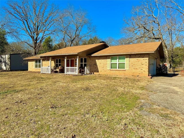 ranch-style home with a garage, covered porch, and a front yard