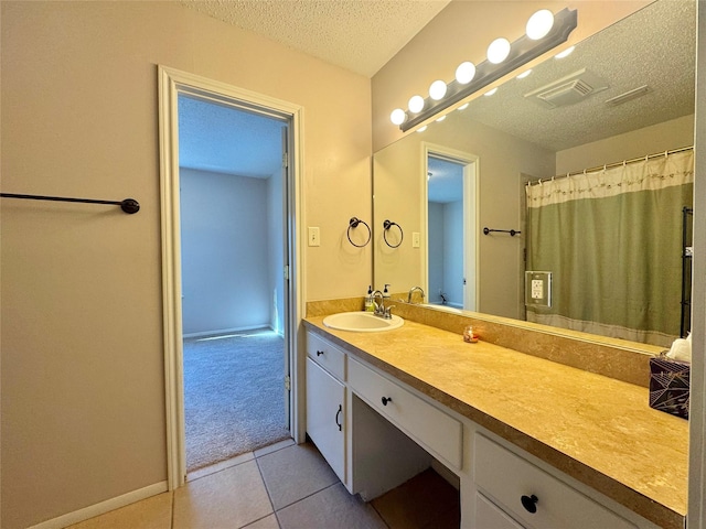 bathroom with tile patterned floors, vanity, a shower with shower curtain, and a textured ceiling