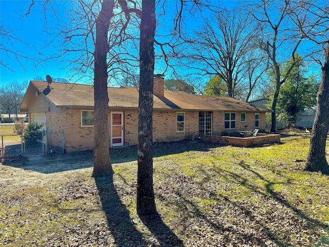 rear view of property with a garage and a lawn