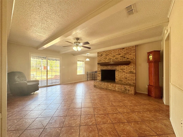 unfurnished living room featuring beam ceiling, ceiling fan, a brick fireplace, tile patterned floors, and a textured ceiling