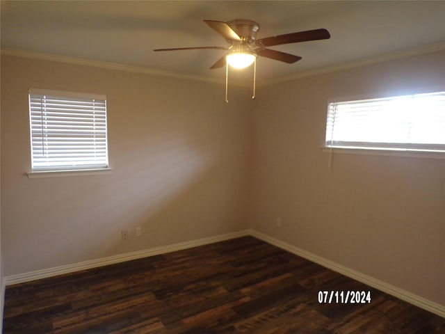 spare room with crown molding, a wealth of natural light, and dark hardwood / wood-style floors