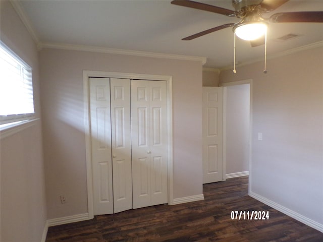 unfurnished bedroom with ornamental molding, ceiling fan, dark hardwood / wood-style flooring, and a closet